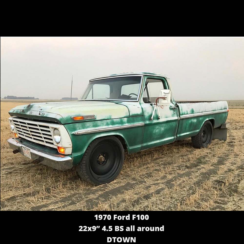 A green truck is parked in the middle of a field.