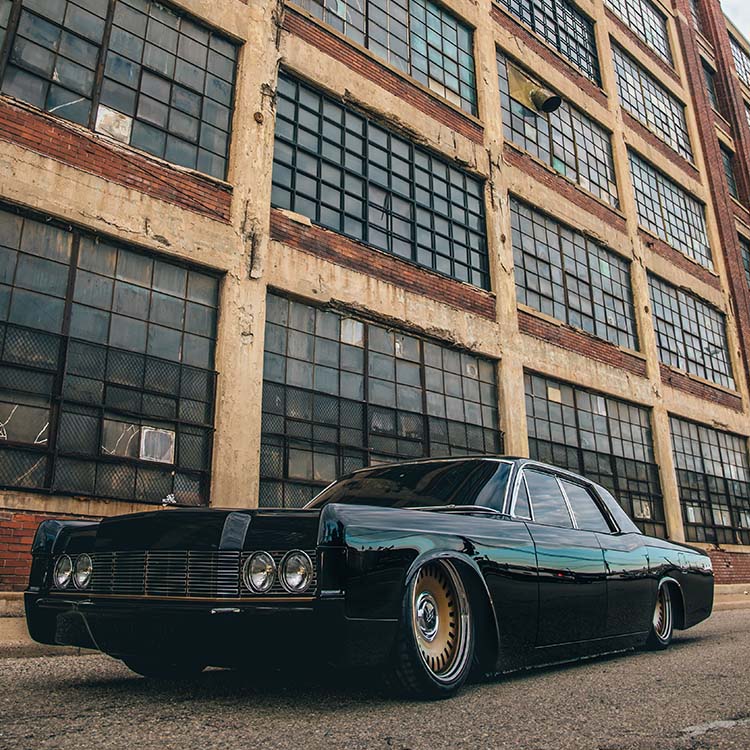 A black car parked in front of an old building.