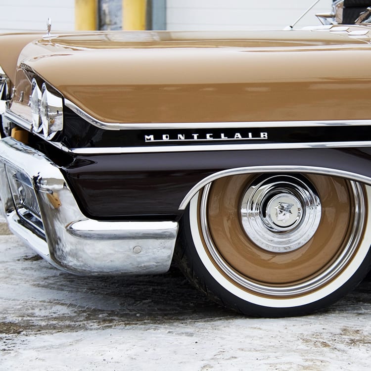 A close up of the front wheel on an old car.