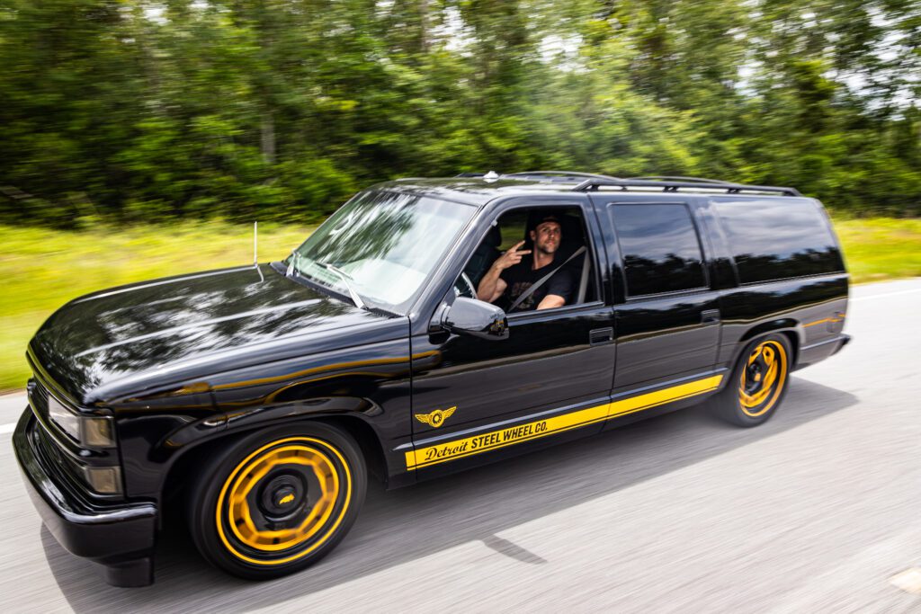 A man driving a black and yellow car